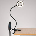 Black USB clip-on ring desk lamp clamped to a desk edge, with inline remote for brightness, color mode and power